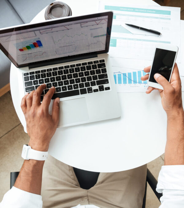 Top view image of young african man sitting coworking Top view image of young african man sitting coworking with laptop computer chatting by phone.